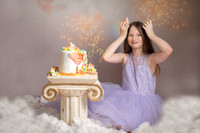 Themed unicorn and golden cloud older child cake smash. Child photographer in Essex and Suffolk offering cake smash and fine art child portraits.