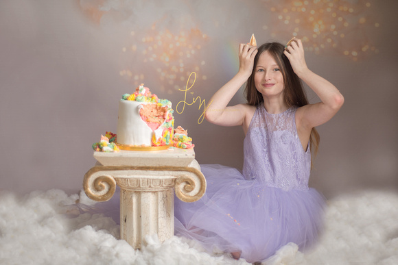 Themed unicorn and golden cloud older child cake smash. Child photographer in Essex and Suffolk offering cake smash and fine art child portraits.